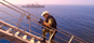 A member of HMCS REGINA's naval boarding party climbs a ships ladder during a boarding of a suspect vessel in the Gulf of Oman. The Canadian frigate, seen in the background, is part of Coalition Task Force 151, and is responsible for escorting ships, intercepting and boarding suspect vessels and guarding against attacks on shipping, in support of Operation APOLLO, Canada's contribution to the international campaign against terrorism.<p><p>Credit:  Sgt Frank Hudec/Canadian Forces Combat Camera